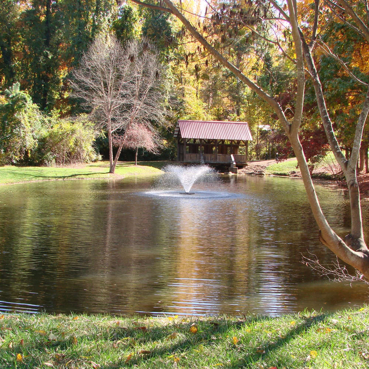 Scott Aerator DA-20 Display Aerator On The Water With Colorful Trees & A Bridge In The Background