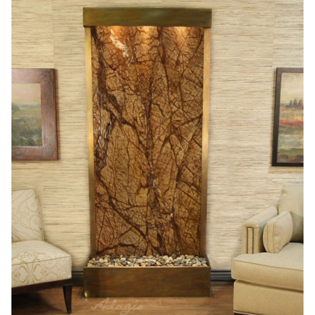 Adagio Tranquil River floor fountain with a brown rainforest marble panel and a pebble basin standing between two cream armchairs