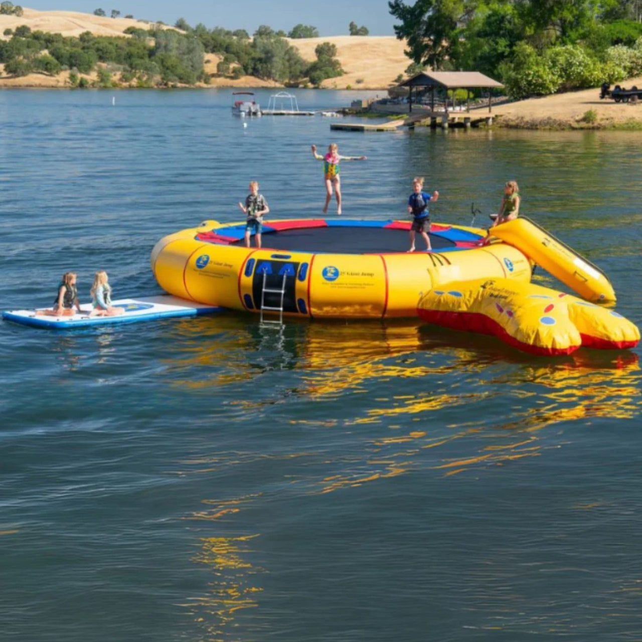 25 Island Hopper Water Trampoline Floating In Calm Water While Kids Playing With Scenic View Background