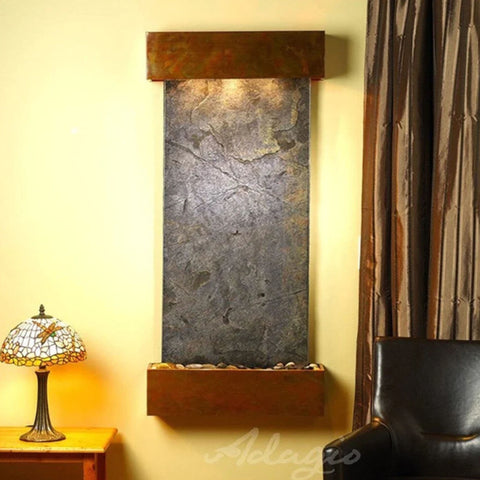 Adagio Water Features Cascade Springs Wall Fountain With A Tiffany-style Stained Glass Table Lamp With A Brown Leather Brown Chair