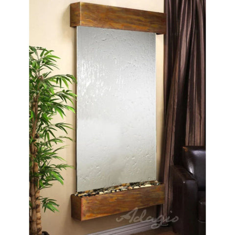 Adagio Water Features Summit Falls Wall Fountain With Artificial Flowers Placed On The Small Table And Leather Chair