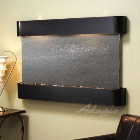 Adagio Water Features Sunrise Springs Wall Fountain With Cream Color Wall and a Lamp Shades