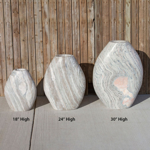 Almond-Shaped Pink Marble Stone Fountain Showing The Three Available Sizes With Wooden Wall Background