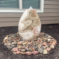 Thumbnail for Almond-Shaped Red Onyx Stone Fountain With Window And Wooden Wall In The Background
