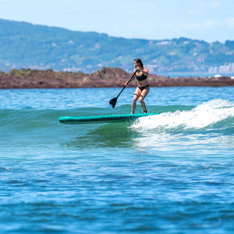 Aqua Marina Breeze Inflatable SUP On The Water With A Girl Ridding A Wave