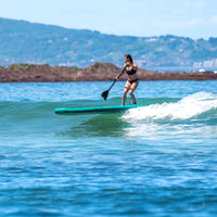 Thumbnail for Aqua Marina Breeze Inflatable SUP On The Water With A Girl Ridding A Wave