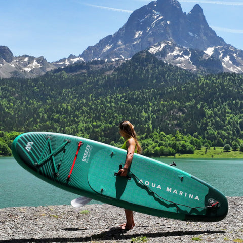 Aqua Marina Breeze isup with a girl carrying and a mountain in the background