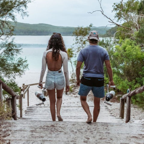 Aqua Marina Bluedrive X Pro Sea Scooter With A Man and Woman Walking Toward the Sea