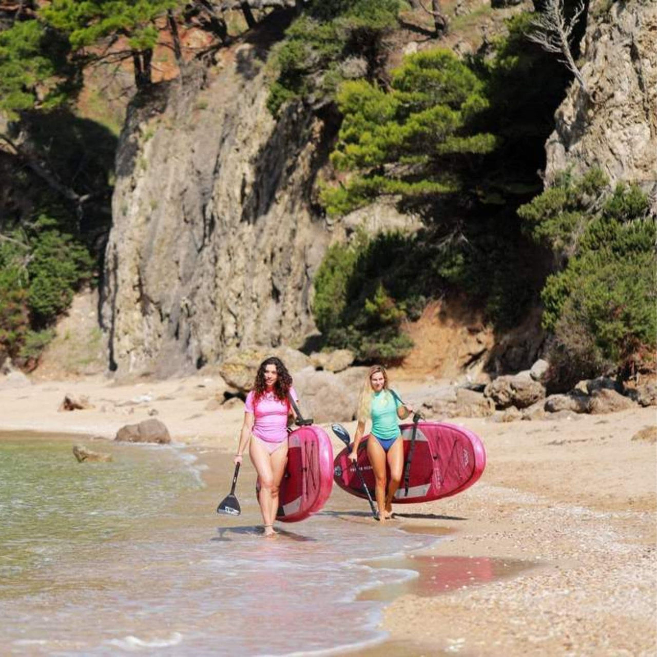 Aqua Marina Coral Paddle Board Two Women Carrying on Their Shoulder