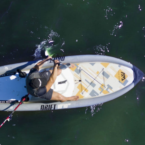 Aqua Marina Drift Fishing Paddle Board With A Seated Man While Paddling On The Water