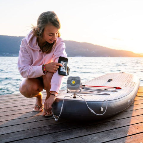 Aqua Marina Glow Paddle Board With A Girl Connecting the Device