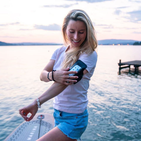 Aqua Marina Glow Paddle Board With A Woman Holding her Arm Strap