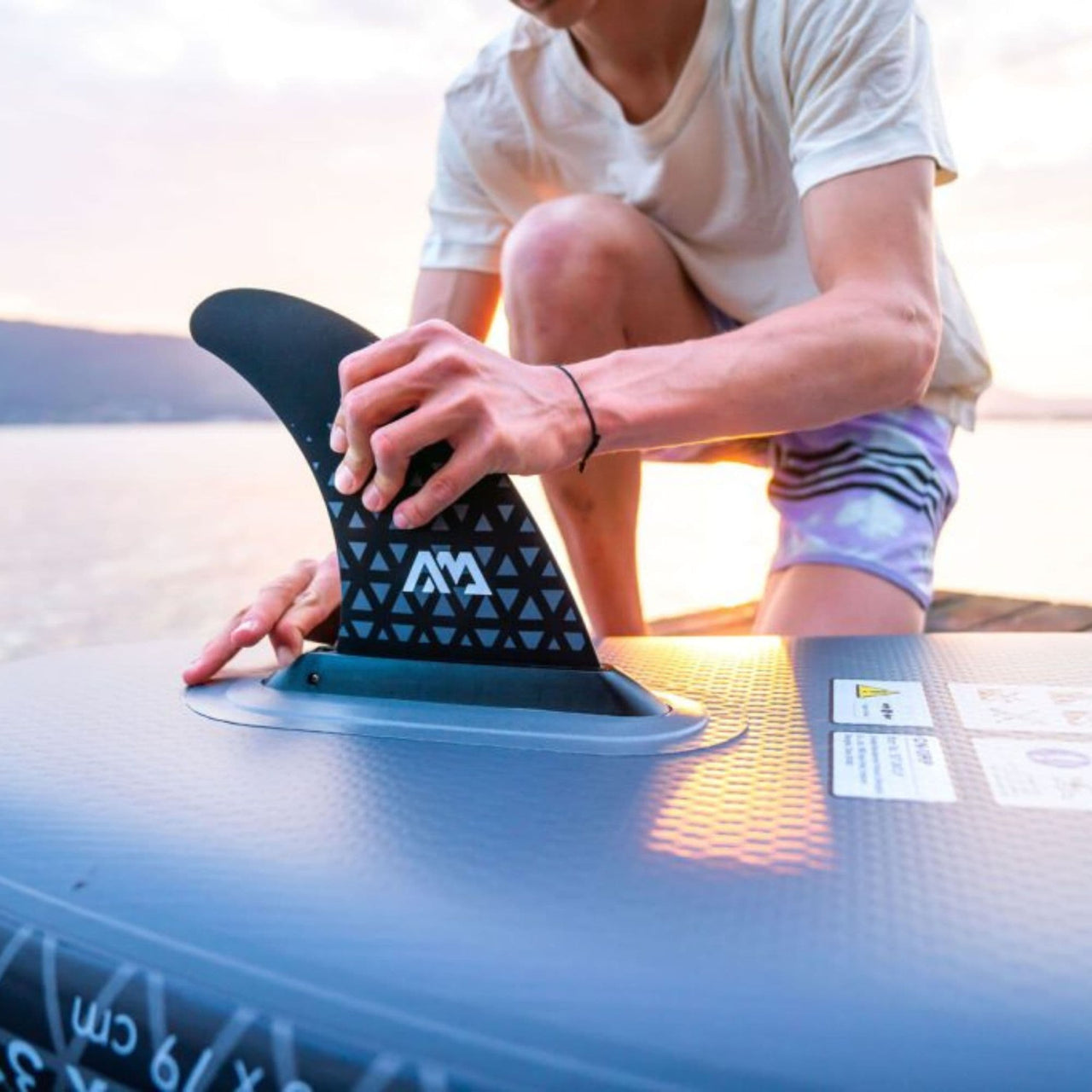 Aqua Marina Glow SUP Man Fixing the Fin