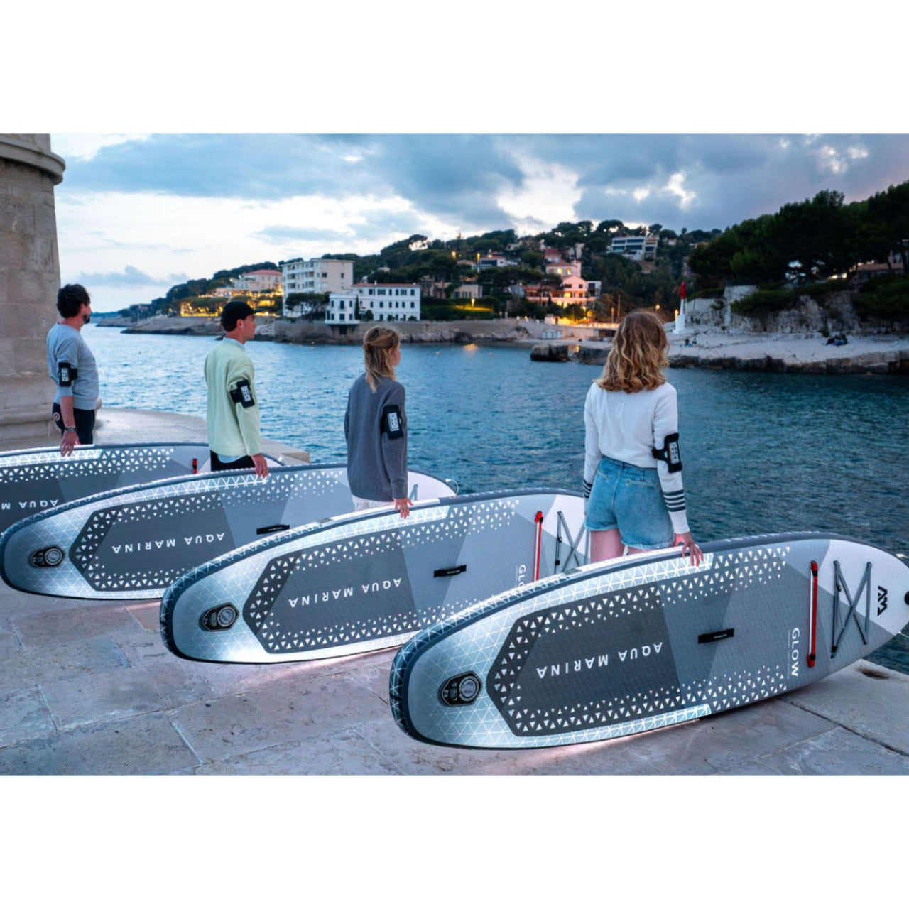Aqua Marina Glow SUP With Two Men and Two Women Are Looking at the Water and Are Ready to Ride Their Boards