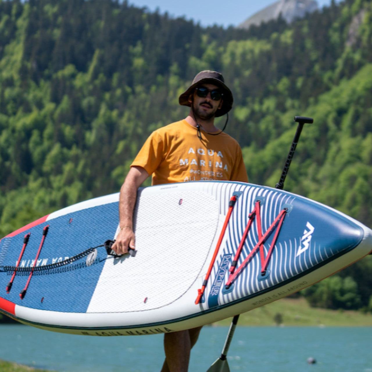 Aqua Marina Hyper SUP With A Man Walking While Carrying a Board