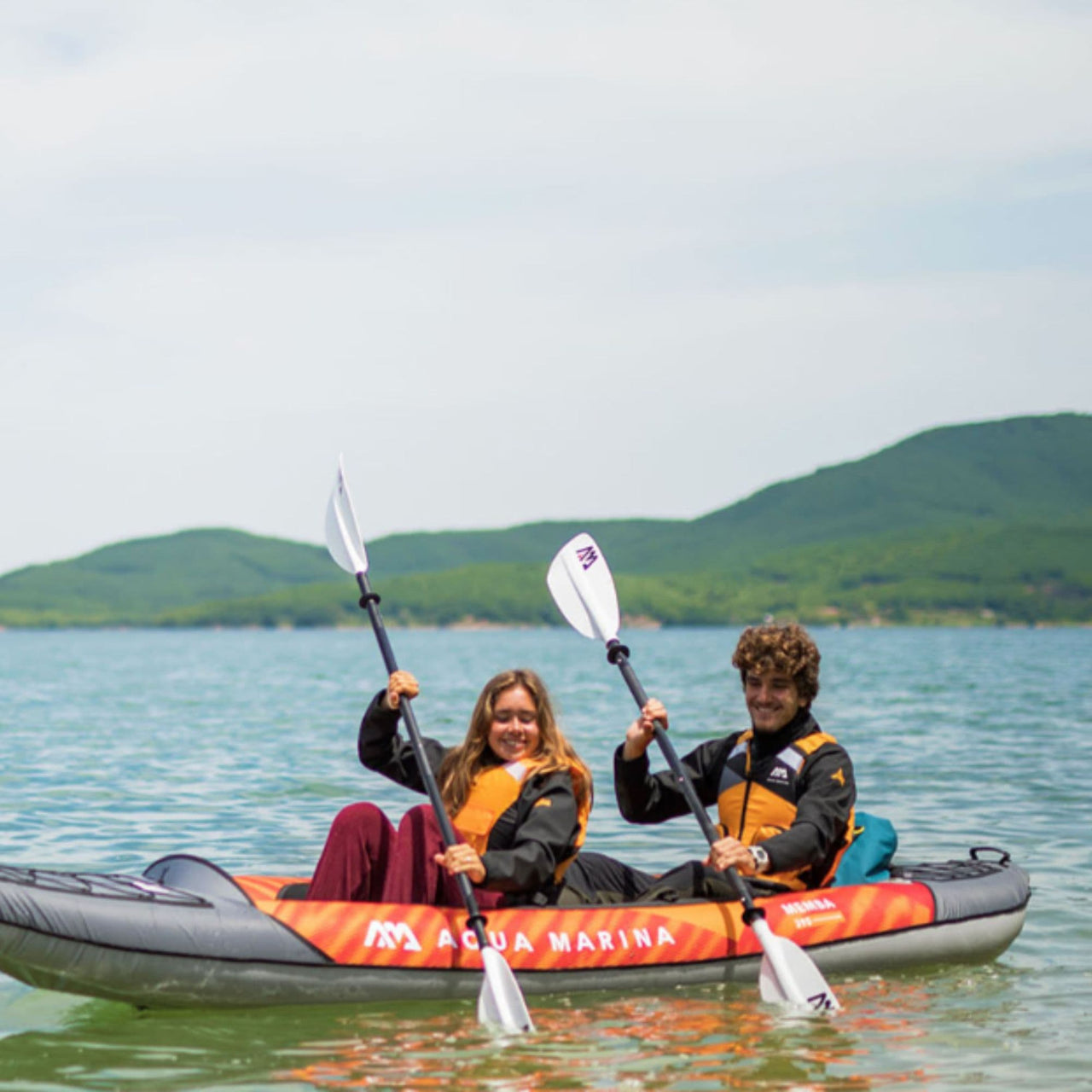 Aqua Marina Memba 390 With A Man And Woman Synchronized Paddling On Calm Water