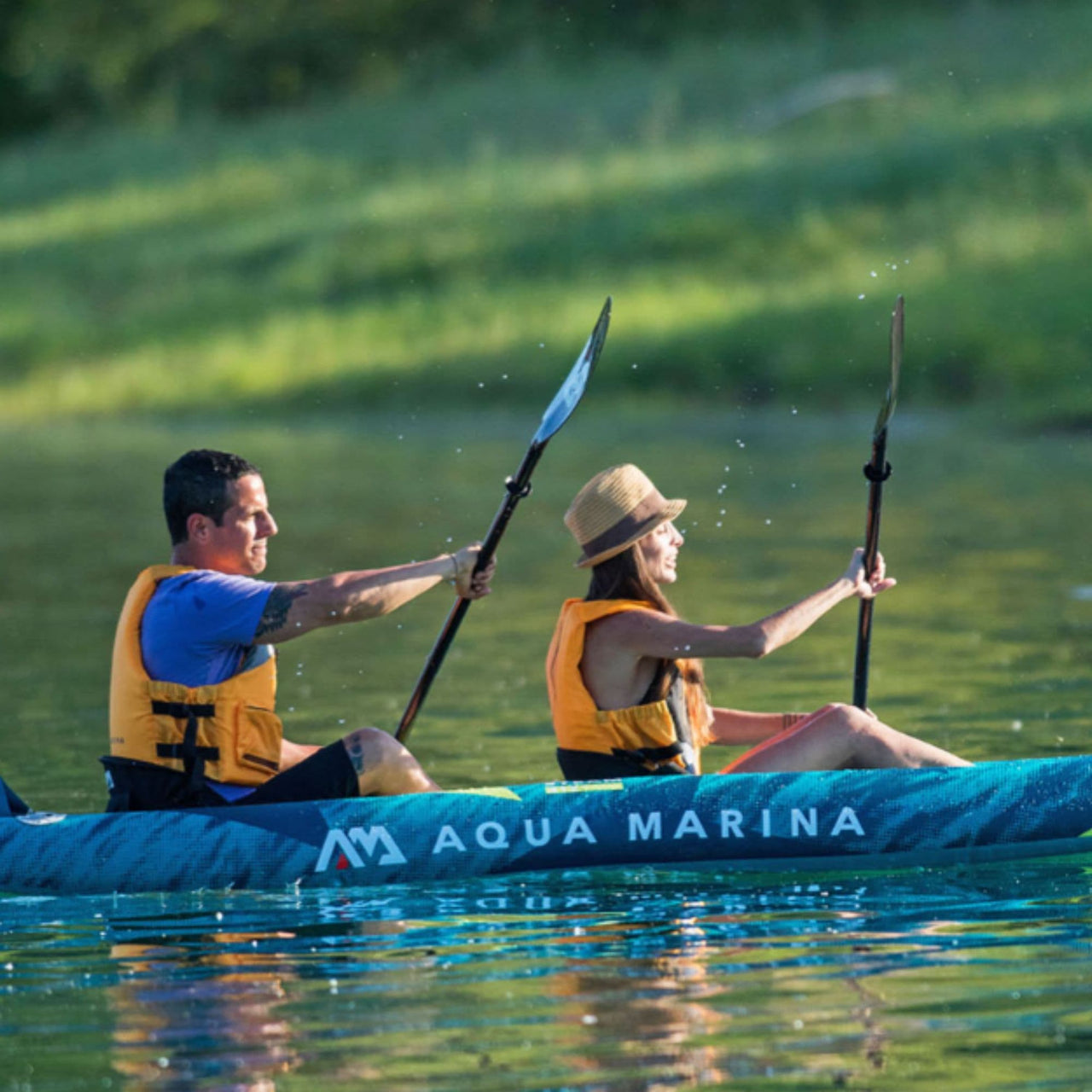 Aqua Marina Steam Kayak With A Man And Woman Synchronized Paddling On Calm Water