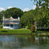 Thumbnail for Aquasweep Max Muck Blaster Freestanding In Shallow Water With Big Houses And Trees In The Background