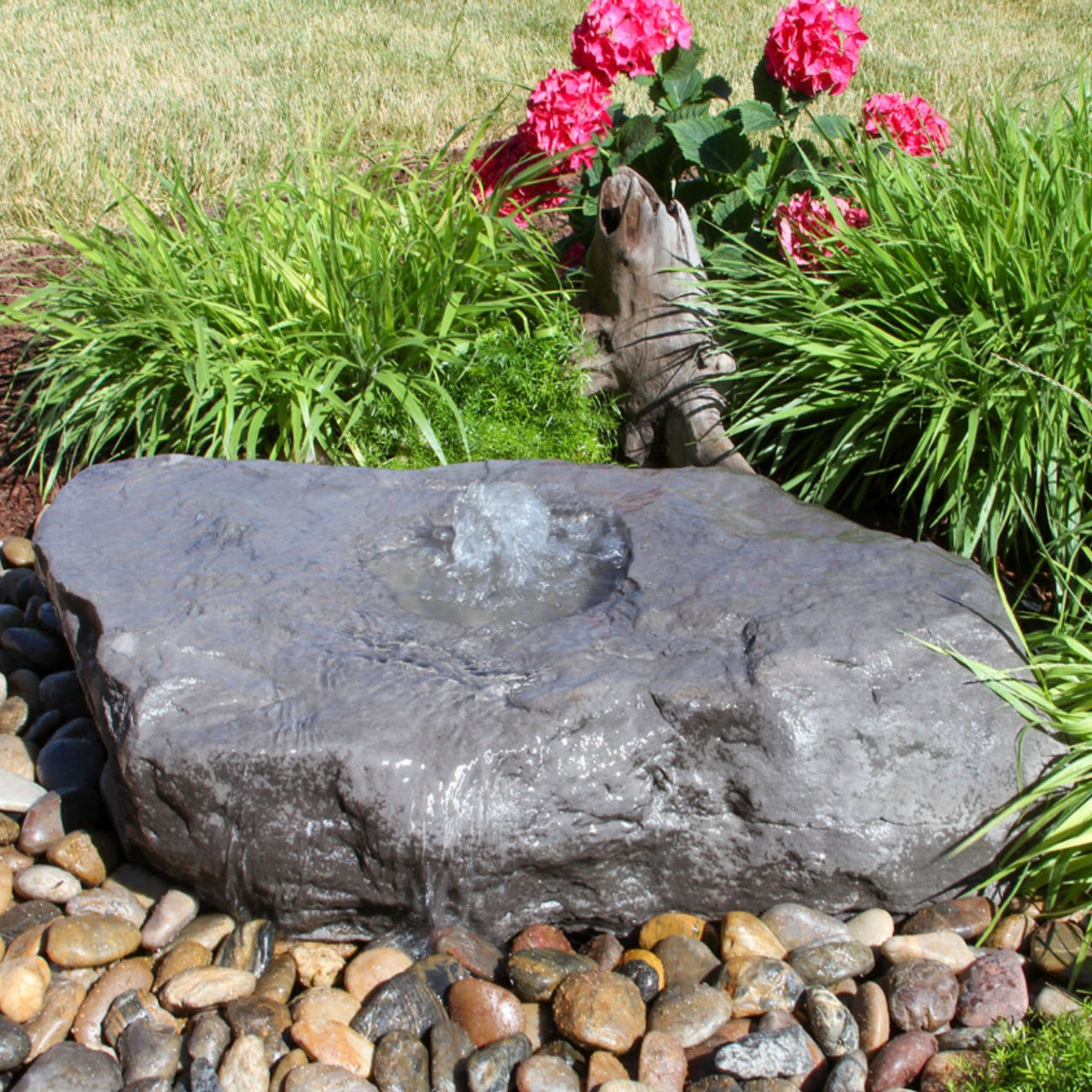 Bird Bath Stone Fountain Outdoor With Bright Ornamental Grass And Flowers