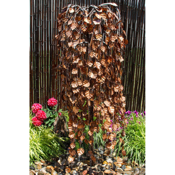 Blue Thumb 60 Copper Weeping Elm Tree Garden Fountain Surrounded By Flowers And Green Plants With Wooden Fence In The Back