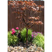 Blue Thumb 70 Copper Extra Tall Maple Tree Garden Fountain Surrounded By Flowers And Green Plants With Wooden Fence In The Back