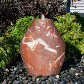 Blue Thumb Almond-Shaped Red Marble Stone Fountain With  Small Trees Or Plants In The Background And Surrounded By Stones