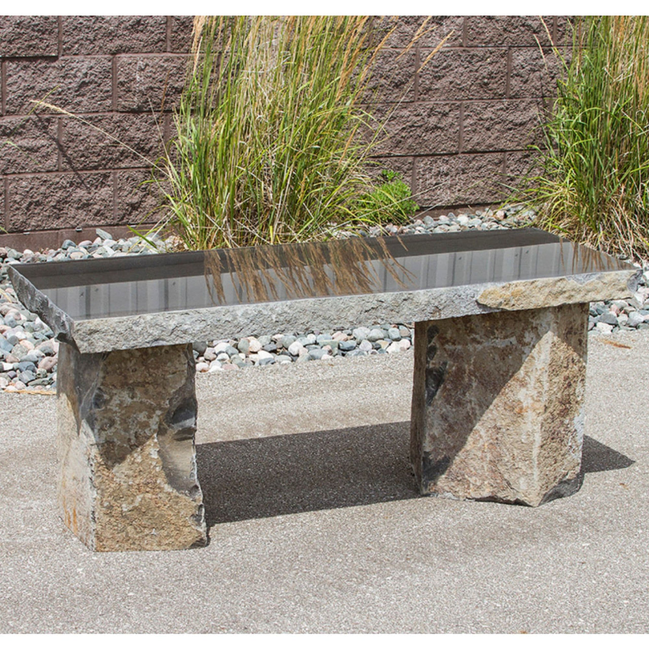 Blue Thumb Basalt 48 Garden Bench With Red Brick Wall And Garden Grass In The Background