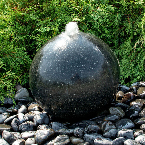 Blue Thumb Black Granite Sphere Stone Fountain With Water Flowing And Green Bushes Behind