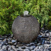 Blue Thumb Black Ribbed Granite Sphere Fountain With Bushes In The Background