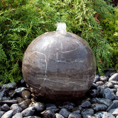 Blue Thumb Blue Limestone Sphere Stone Fountain With Bushes In The Background