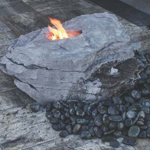 Blue Thumb Boulder Outdoor Fire Stone Fountain With A Fire And Surrounded by Black Pebbles