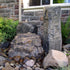 Thumbnail for Blue Thumb Cascade Mini-Mountain Spring Triple Stone Outdoor Fountain With Brick Wall, Window, And Plants In The Background