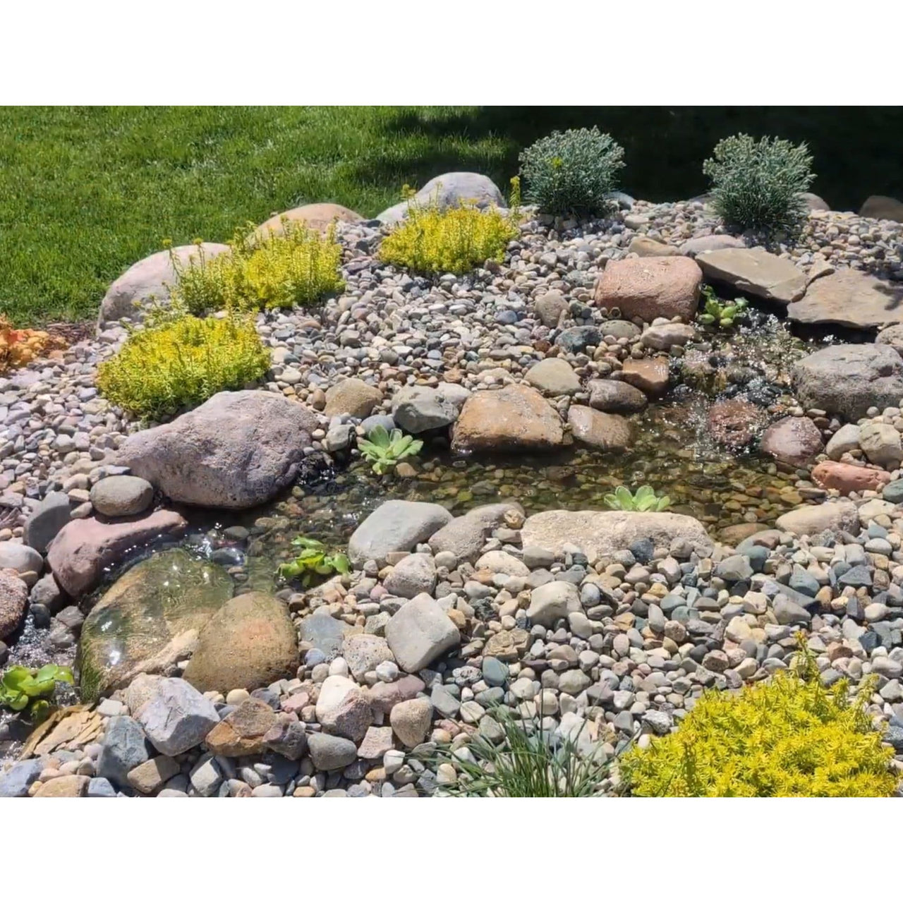 Blue Thumb DIY Medium Cascading Pondless Waterfall Kit Surrounded By Stones And Green Grass Background