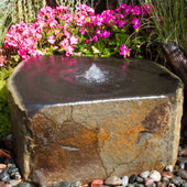 Blue Thumb Keki Stone Outdoor Fountain Beside Grass And Pink Flowers