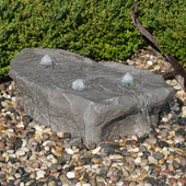 Blue Thumb Manistique Falls Stone Outdoor Fountain Surrounded By Stone With Plants Behind