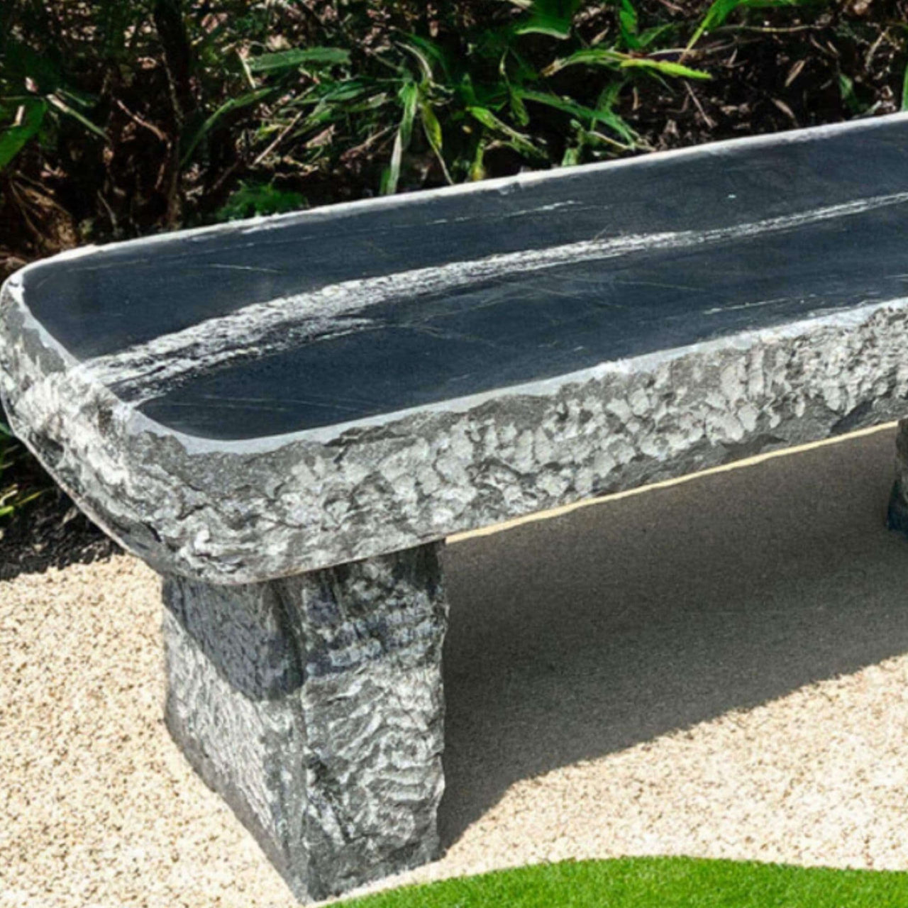 Blue Thumb Mountain Wave Granite 48 Garden Bench Close-up View Placed On A Beige Gravel With Curved Green Lawn And Garden Bushes