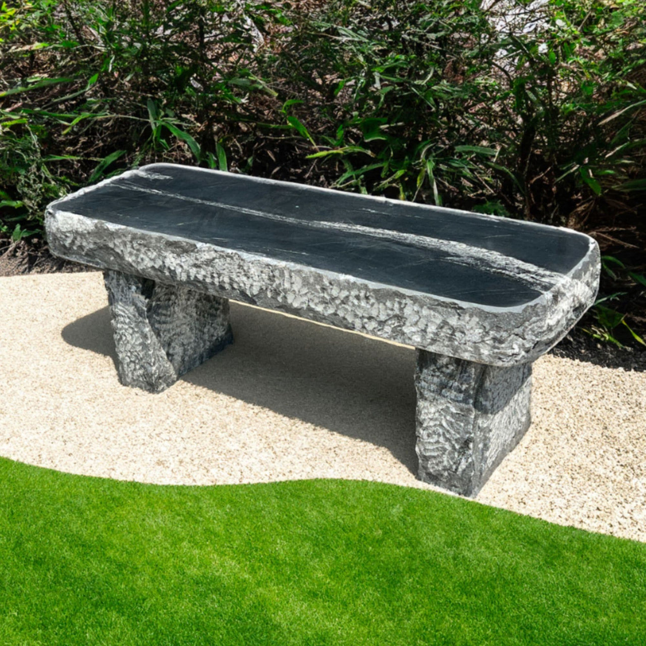 Blue Thumb Mountain Wave Granite 48 Garden Bench Placed On Beige Gravel With Curved Green Lawn And Garden Bushes
