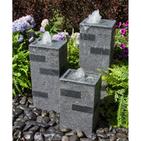 Thumbnail for Blue Thumb Polished Block Stone Towers Outdoor Fountain Surrounded By Ferns And Flowers With Red Trees Behind