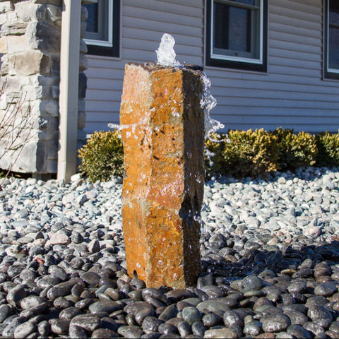 Blue Thumb Rustic Basalt Rock Column Fountain With House In The Background