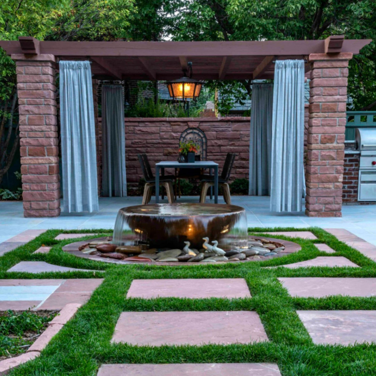 Blue Thumb Rustic Sugar Kettle Powder-Coated Cast Iron Fountain On Cozy Patio With Dining Area