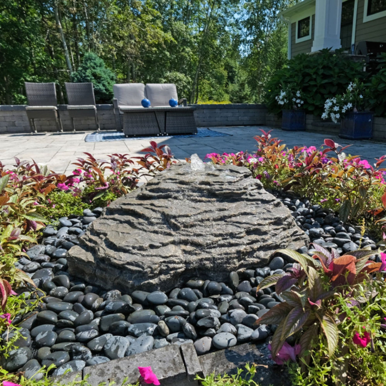 Blue Thumb Slate River Falls Stone Fountain Surrounded By Plants With Modern House And Chairs Background