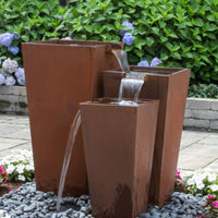Thumbnail for Blue Thumb Triple Corten Steel Rusted Outdoor Fountain Surrounded By White And Pink Flowers With Purple Flowers In The Back
