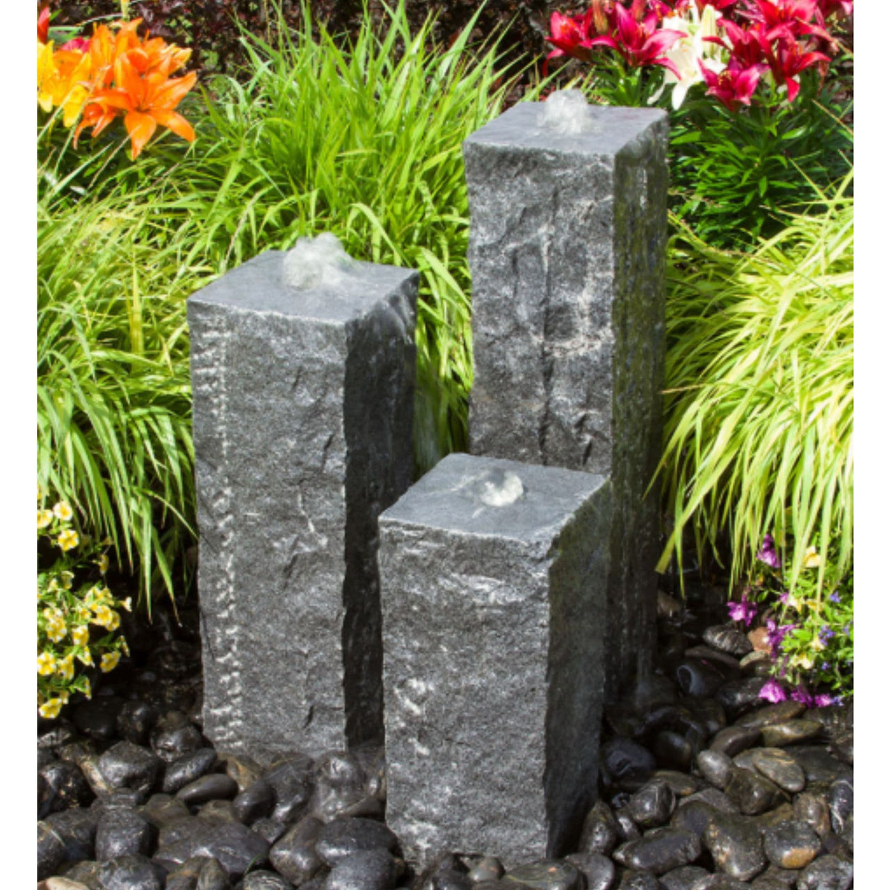 Blue Thumb Triple Raw Cut - Granite Stone Fountain Surrounded By Plants And Flowers