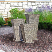 Blue Thumb Triple Stone Urn Outdoor Fountain With White Brick Wall And Green Bushes