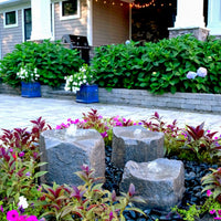 Thumbnail for Blue Thumbs Triple Falls Garden Stone Fountain With Colorful Flowers And Green Bushes