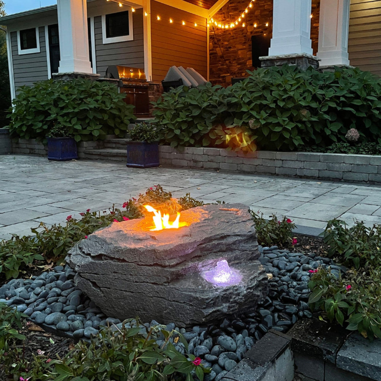 Boulder Fountain with Fire Feature With Big House Behind