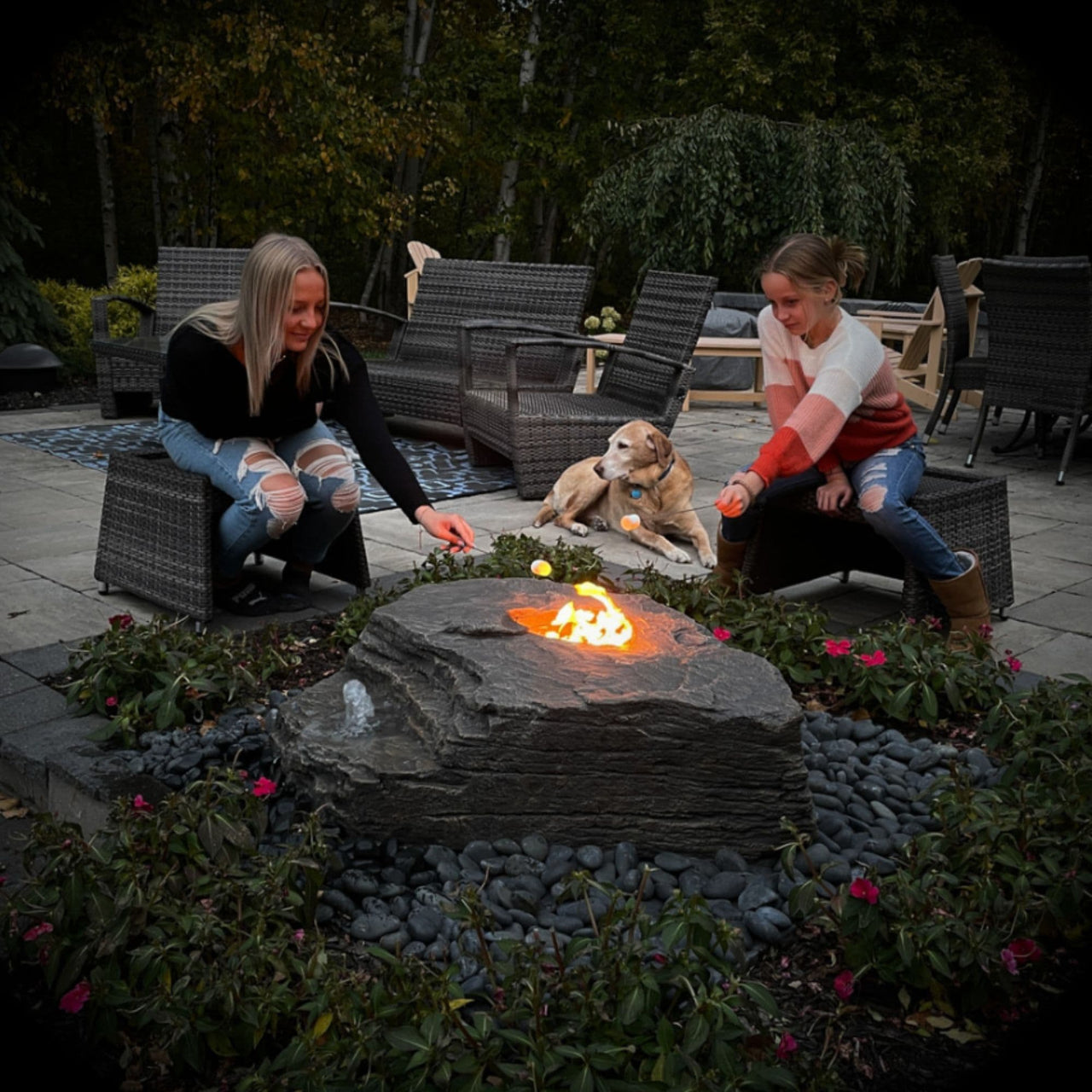 Boulder Outdoor Fire Stone Fountain With A Girls Roasting With Dog Nearby