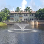 Cascade Saturn Pond Fountain On The Water With A House In The Background
