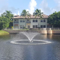 Thumbnail for Cascade Saturn Pond Fountain On The Water With A House In The Background