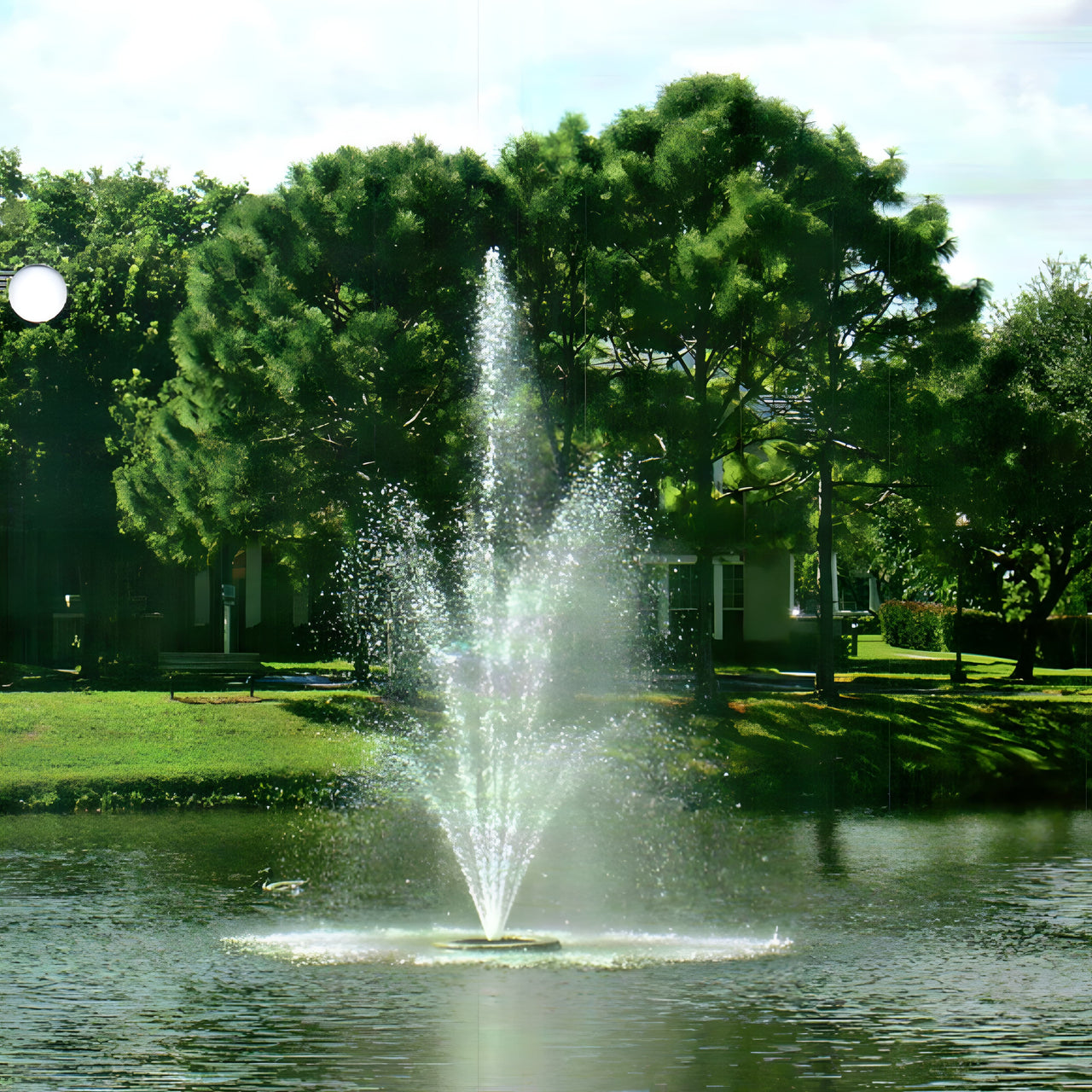 Cascade Aries Series Pond Fountain With Trees And A House In The Background